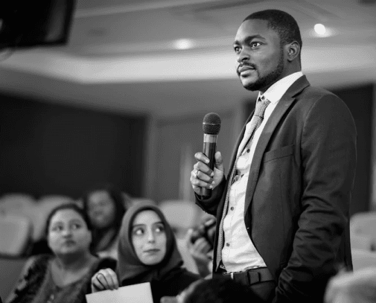 a man in a conference holding A mich